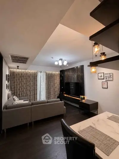 Modern living room with stylish decor and cozy ambiance, featuring a sleek sectional sofa and elegant lighting.