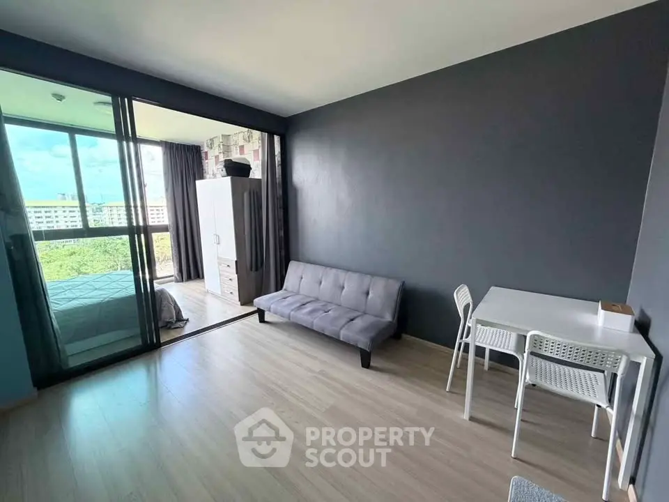 Modern studio apartment with open layout and large windows offering a scenic view.