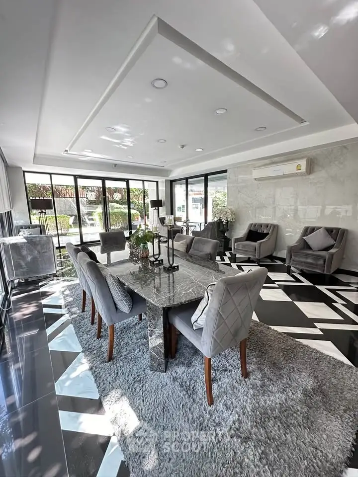 Luxurious dining area with elegant marble table and plush chairs, featuring floor-to-ceiling windows and modern decor.