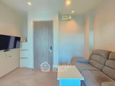 Modern living room with sleek furniture and wall-mounted TV in a cozy apartment.