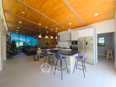 Spacious open-plan kitchen and living area with modern design and wooden ceiling