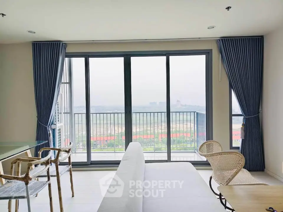 Spacious living room with panoramic view and modern decor in high-rise apartment.