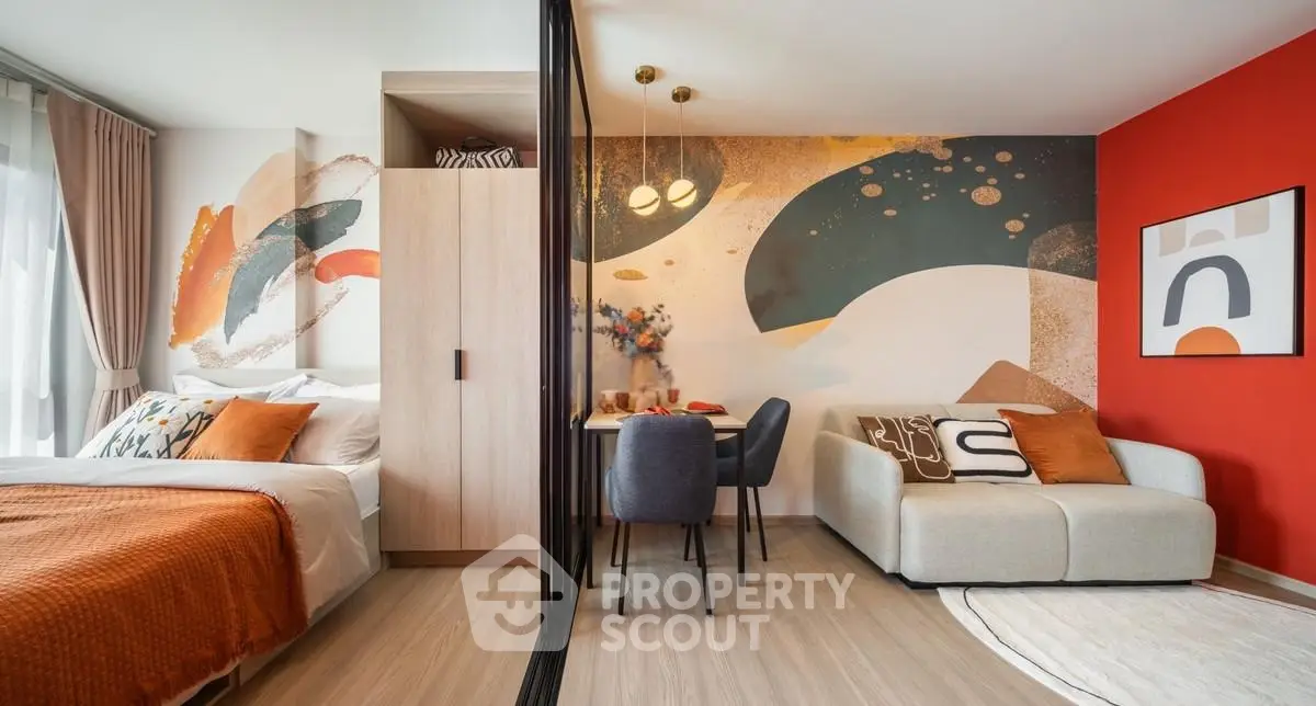 Modern studio apartment with stylish decor, featuring a cozy bed, chic dining area, and vibrant wall art.