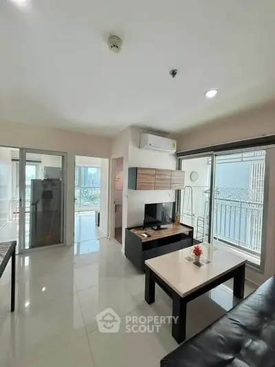 Modern living room with sleek furniture and balcony access in a bright apartment.