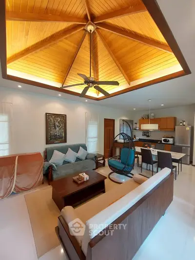 Spacious living room with high wooden ceiling and modern kitchen in open layout