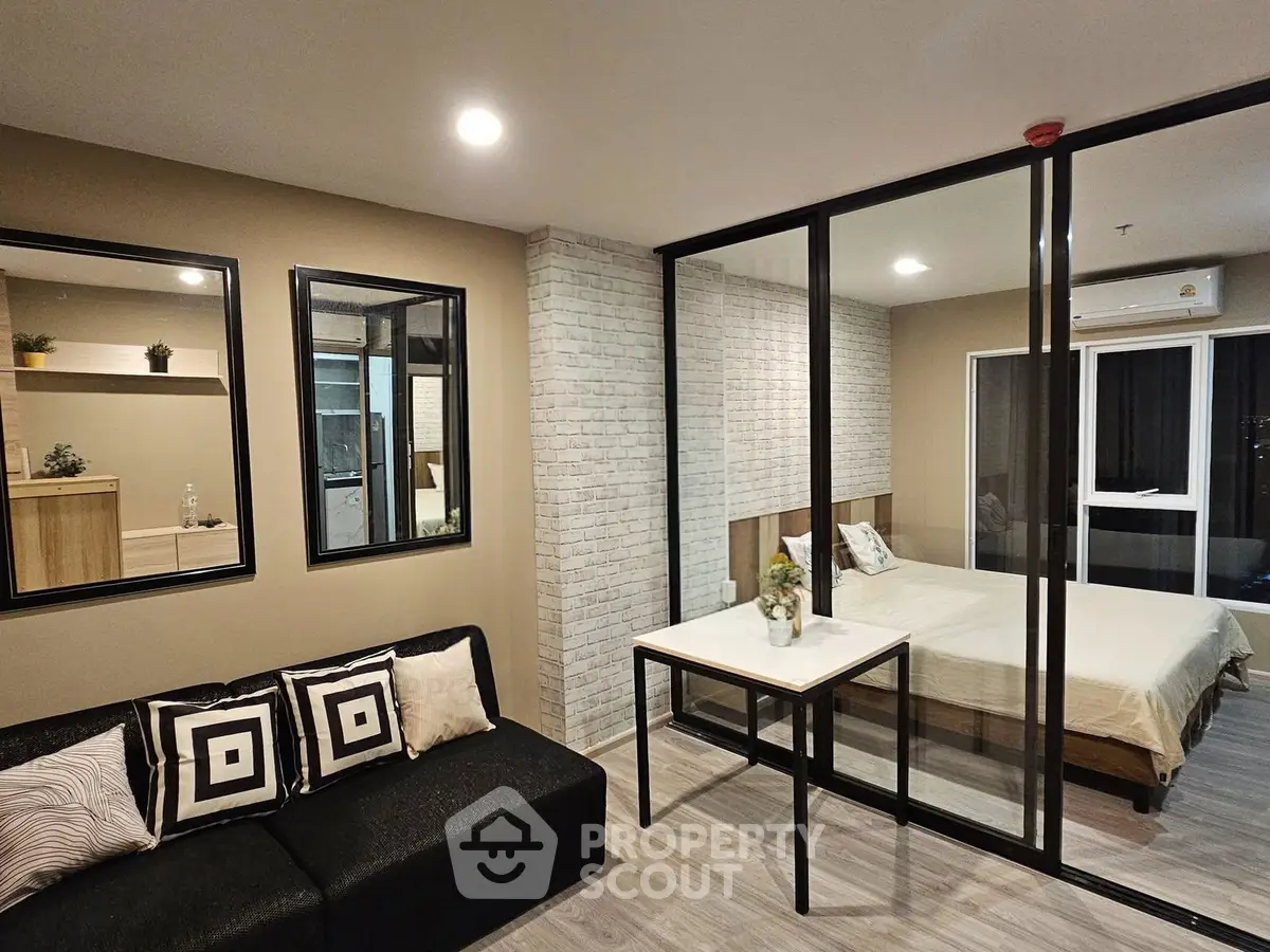 Modern studio apartment with glass partition, stylish decor, and cozy ambiance.