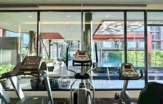 Modern gym with pool view in luxury residential complex