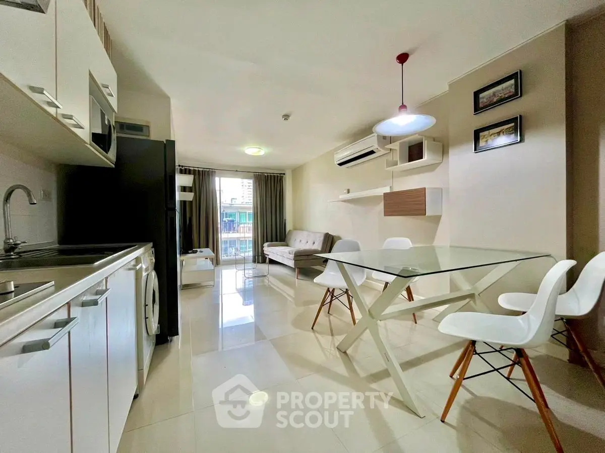 Modern open-plan living room and kitchen with sleek furniture and natural light.