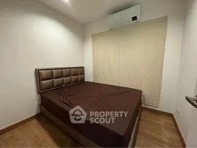 Cozy bedroom with air conditioning and wooden flooring, perfect for restful nights.