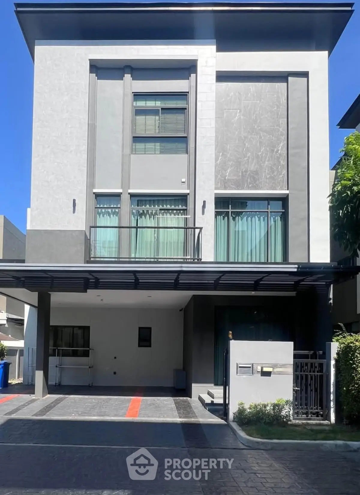 Modern three-story house with sleek facade and spacious driveway