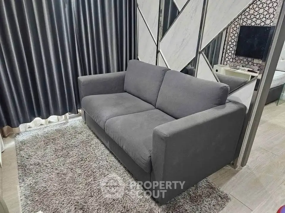 Modern living room with stylish gray sofa and plush rug, perfect for cozy relaxation.