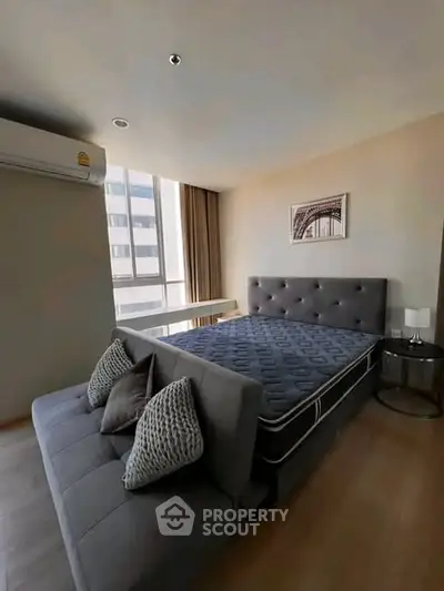 Modern bedroom with stylish decor and large window in urban apartment