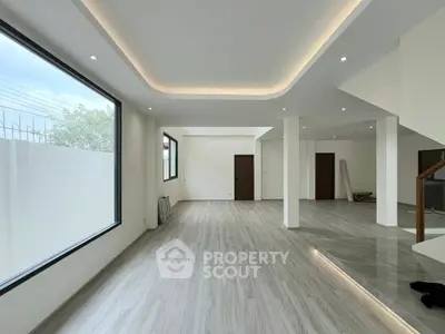 Spacious modern living room with large windows and elegant lighting