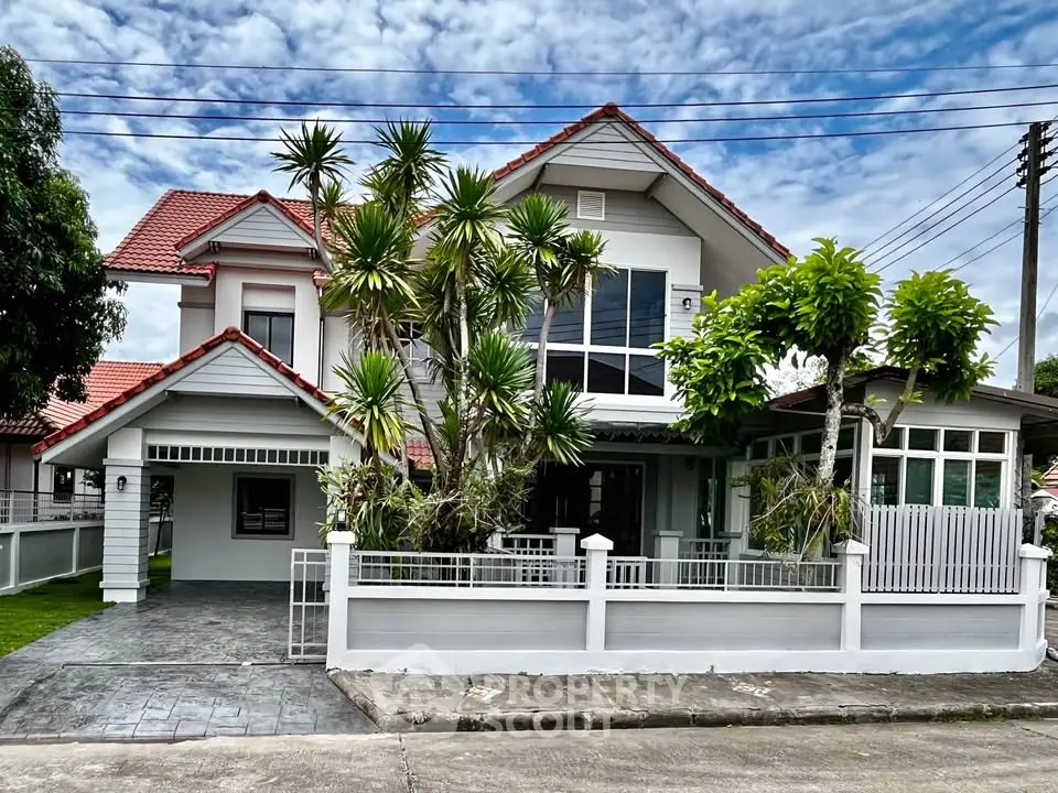 Charming two-story house with lush landscaping and red-tiled roof in a serene neighborhood.