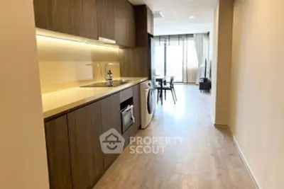 Modern kitchen with wooden cabinets and open layout leading to dining area with natural light.