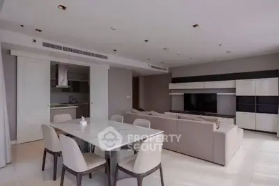 Spacious modern living room with open kitchen and elegant dining area in luxury apartment.