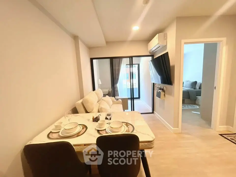 Modern living room with dining area and balcony access in a stylish apartment.