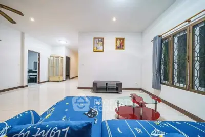 Spacious living room with modern decor and ample natural light.