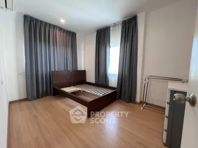 Spacious bedroom with wooden flooring and large windows in modern apartment