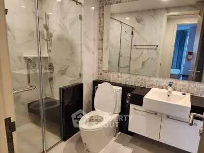 Modern bathroom with glass shower and sleek fixtures in a contemporary apartment.