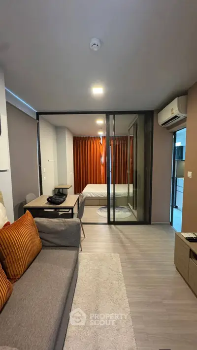 Modern studio apartment with glass partition, cozy living area, and stylish decor.