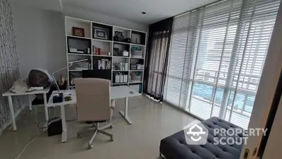 Modern study room with large windows and stylish furniture in a high-rise apartment.