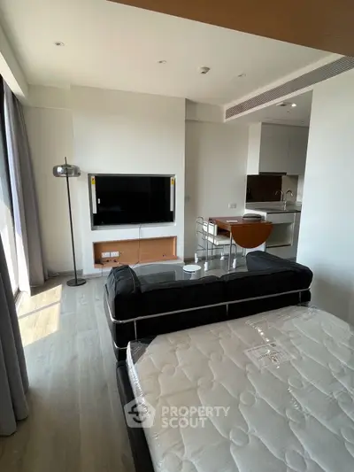 Modern studio apartment with sleek kitchen and cozy living area, perfect for urban living.