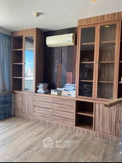 Spacious study room with wooden cabinets and air conditioning, perfect for home office setup.
