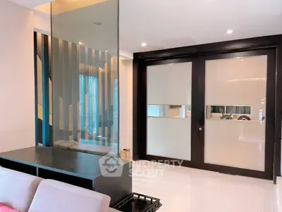 Modern living room with sleek glass partition and sliding doors