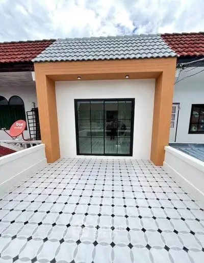 Charming townhouse with modern facade and spacious tiled balcony, perfect for outdoor relaxation.