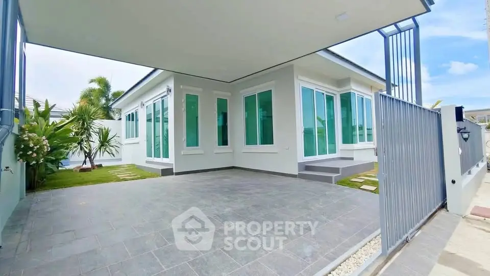 Modern single-story house with spacious driveway and lush garden