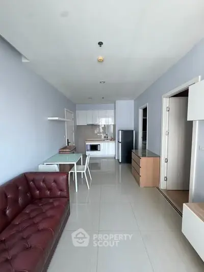 Modern living room with sleek furniture and open kitchen layout in a stylish apartment.