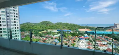 Stunning high-rise balcony view overlooking lush green hills and vibrant cityscape.