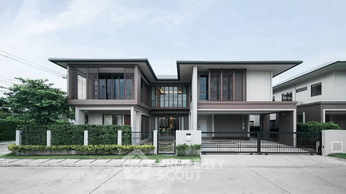 Modern two-story house with sleek design and lush greenery, perfect for contemporary living.