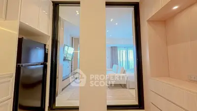 Modern apartment interior with sleek kitchen and cozy living room, featuring stylish furniture and bright lighting.