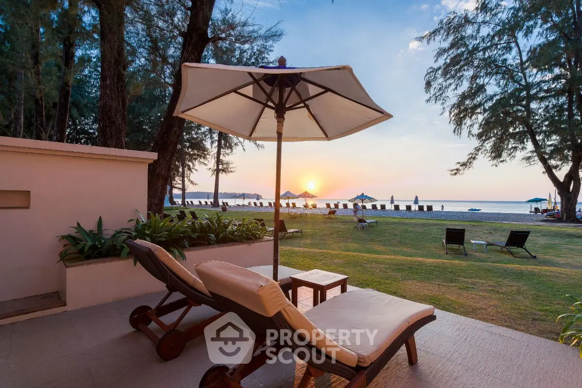 Luxurious beachfront property with stunning sunset view and relaxing outdoor lounge area.