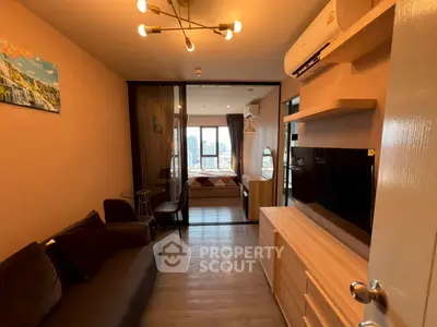 Modern living room with stylish decor and open view to bedroom, featuring sleek furniture and ambient lighting.