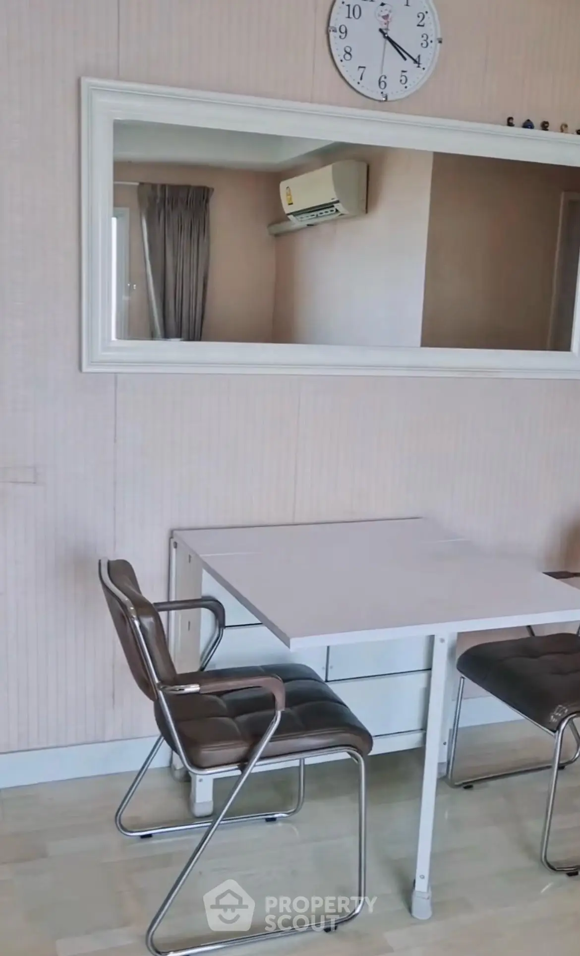 Chic dining area with modern chairs and wall mirror in stylish apartment.