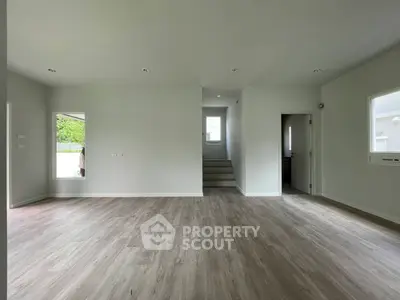 Spacious empty room with modern flooring and natural light