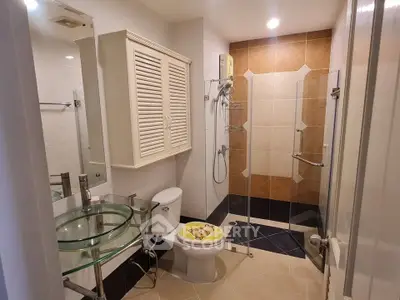 Modern bathroom with glass shower and stylish fixtures in a contemporary home.