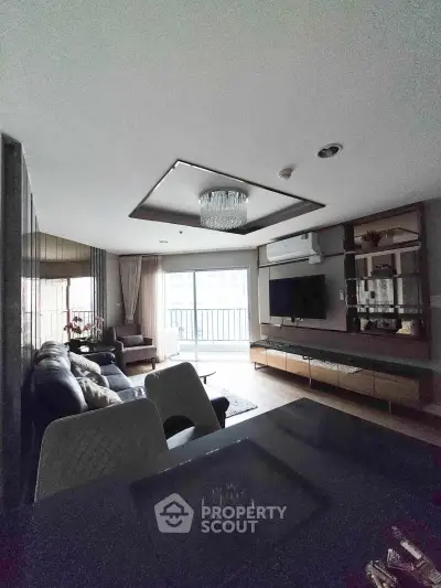 Luxurious living room with modern decor and balcony view in upscale apartment.