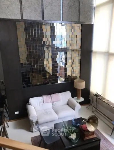Stylish loft living room with modern decor and large reflective wall art