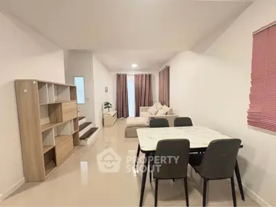 Spacious modern living room with dining area and stylish furniture in a contemporary home.