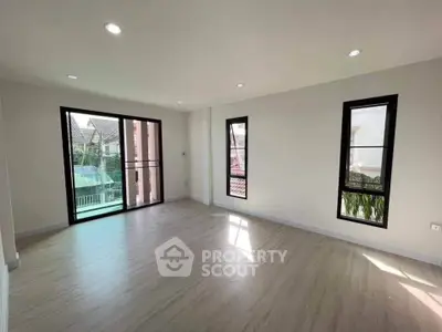 Spacious unfurnished room with large windows and balcony access in modern home