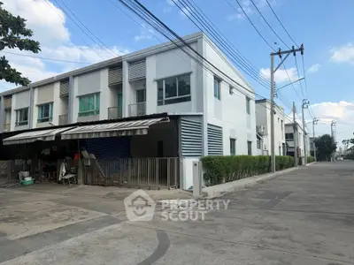 Modern townhouse exterior with clean lines and lush greenery in a suburban neighborhood.