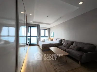 Modern studio apartment with cozy living area and large windows