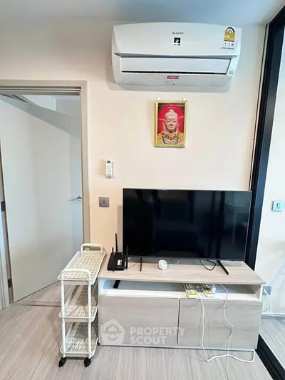 Modern living room with sleek TV setup and air conditioning unit, perfect for comfortable living.