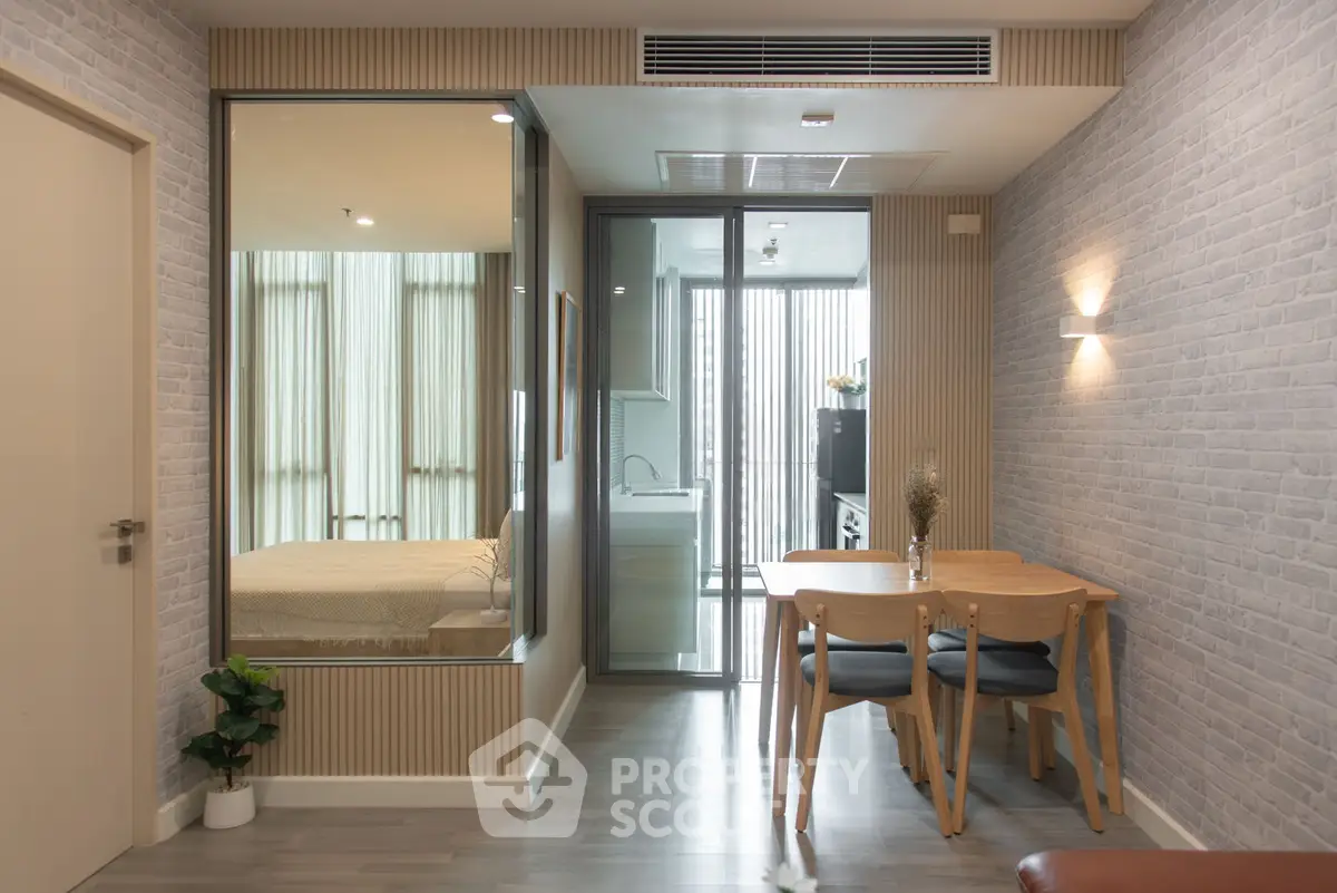Modern apartment interior with dining area and view into bedroom and kitchen.
