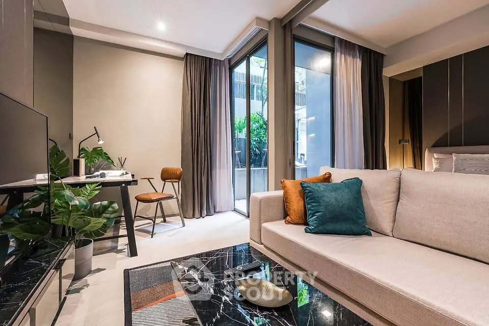 Modern living room with stylish decor and large windows offering natural light.