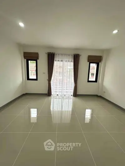 Spacious empty room with large windows and glossy tiled floor, perfect for customization.
